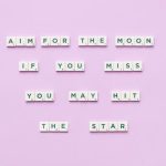 Inspirational message using Scrabble tiles on a pastel background.