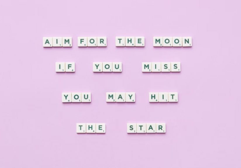 Inspirational message using Scrabble tiles on a pastel background.